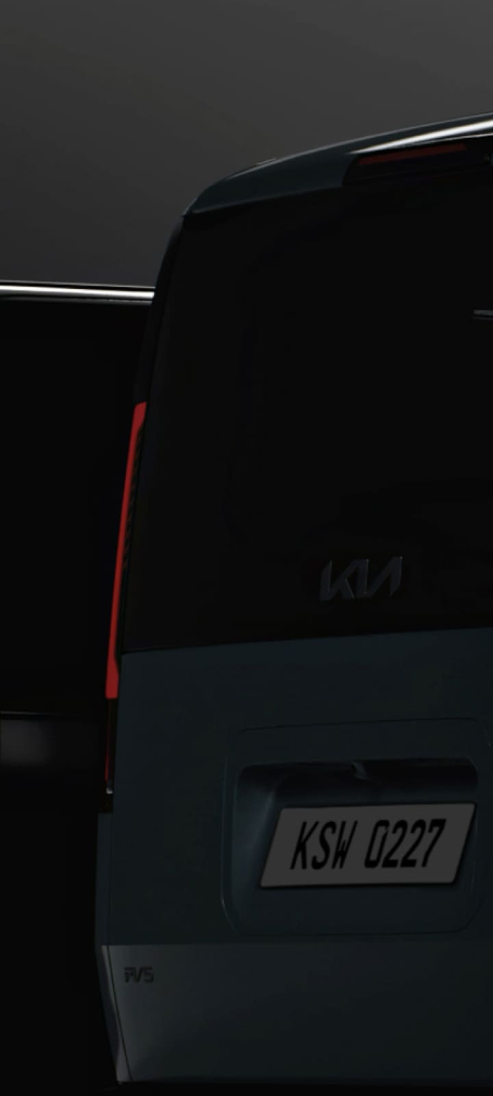 Rear view of the Kia PV5 Cargo in low light, emphasizing the tail lamps