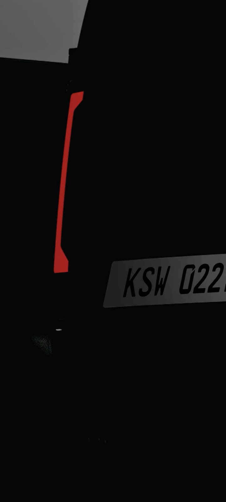 Rear view of the Kia PV5 Cargo in low light, emphasizing the tail lamps